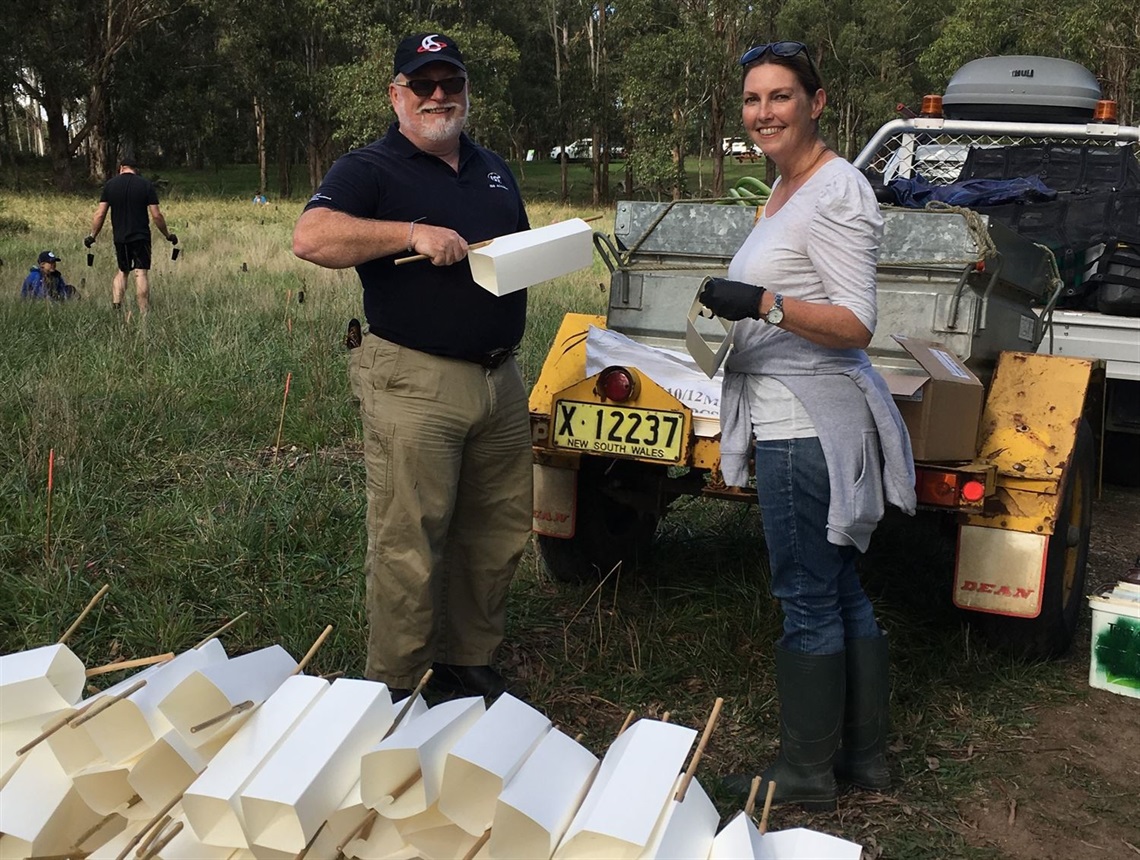 Image of man and women in front of trailer with planting equipment for planting day