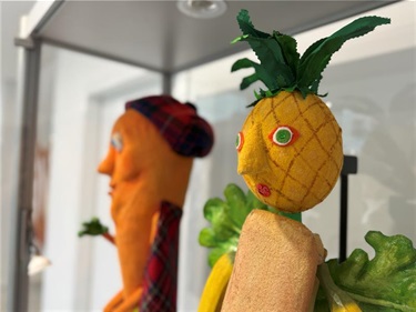 Carrot in a kilt puppet and tropical fruit puppet with a pineapple head and banana arms