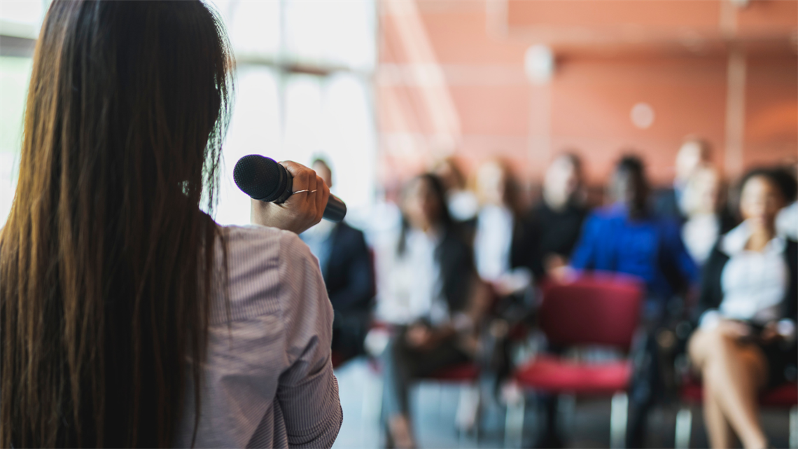 Lady talking to audience in microphone