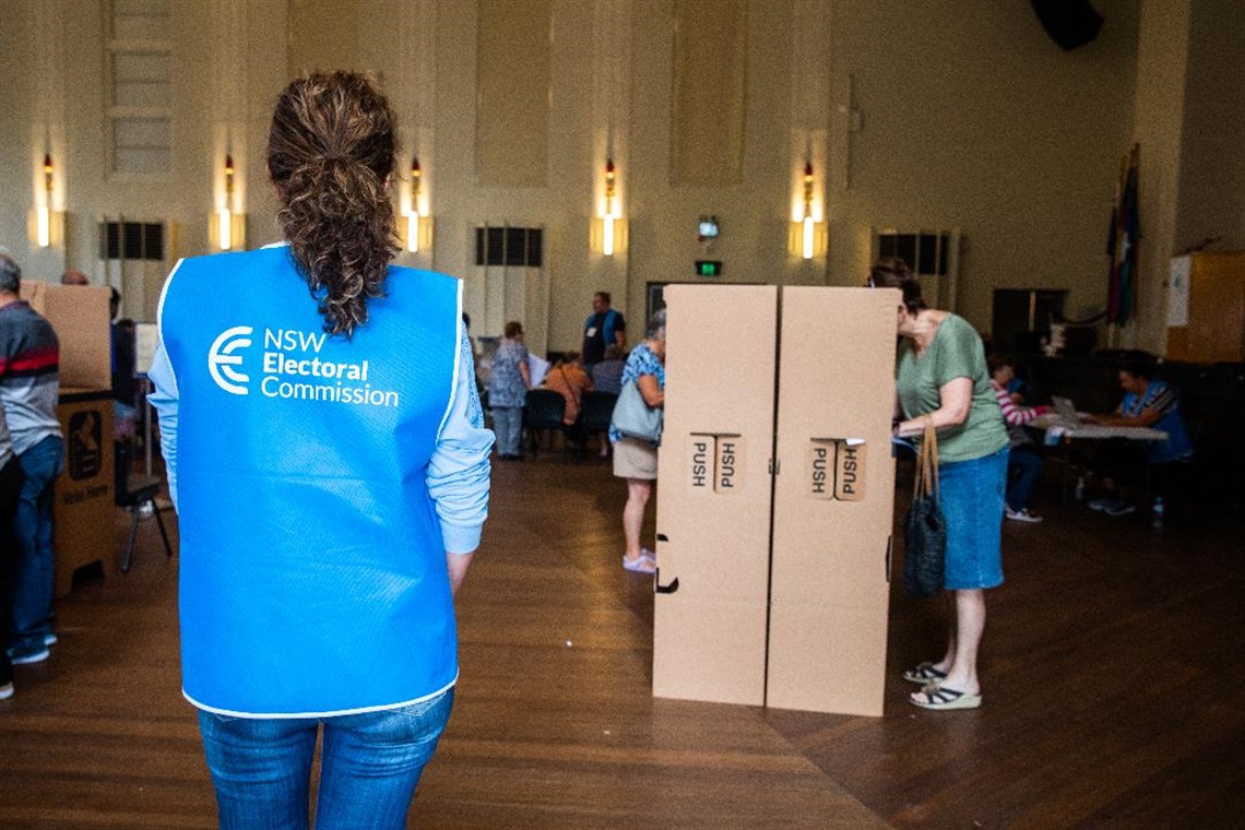 photo of an electoral commission worker at voting booth