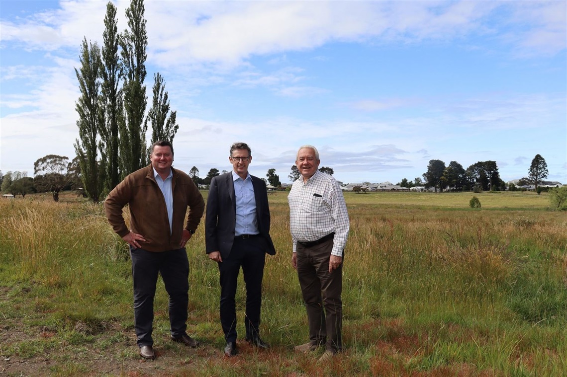 Three people standing at a field