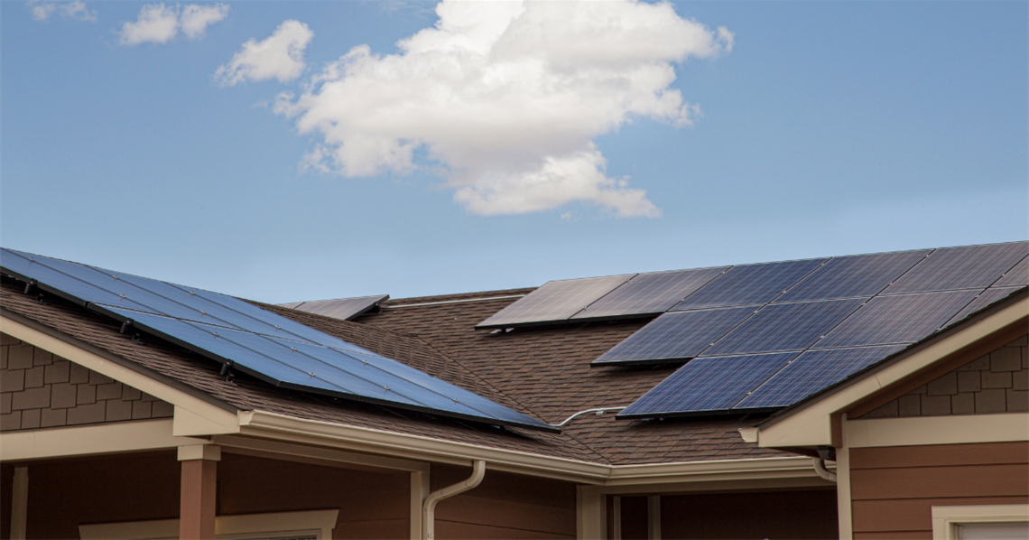 House roof with solar panels, blue sky