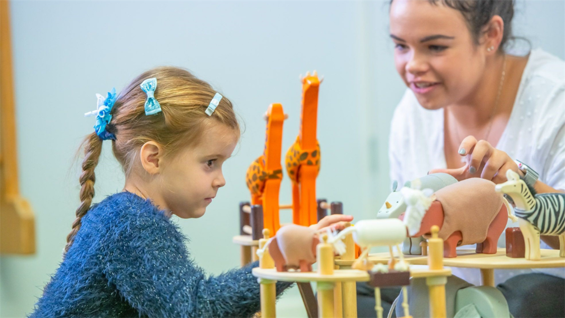 teacher working with young child with educational toys