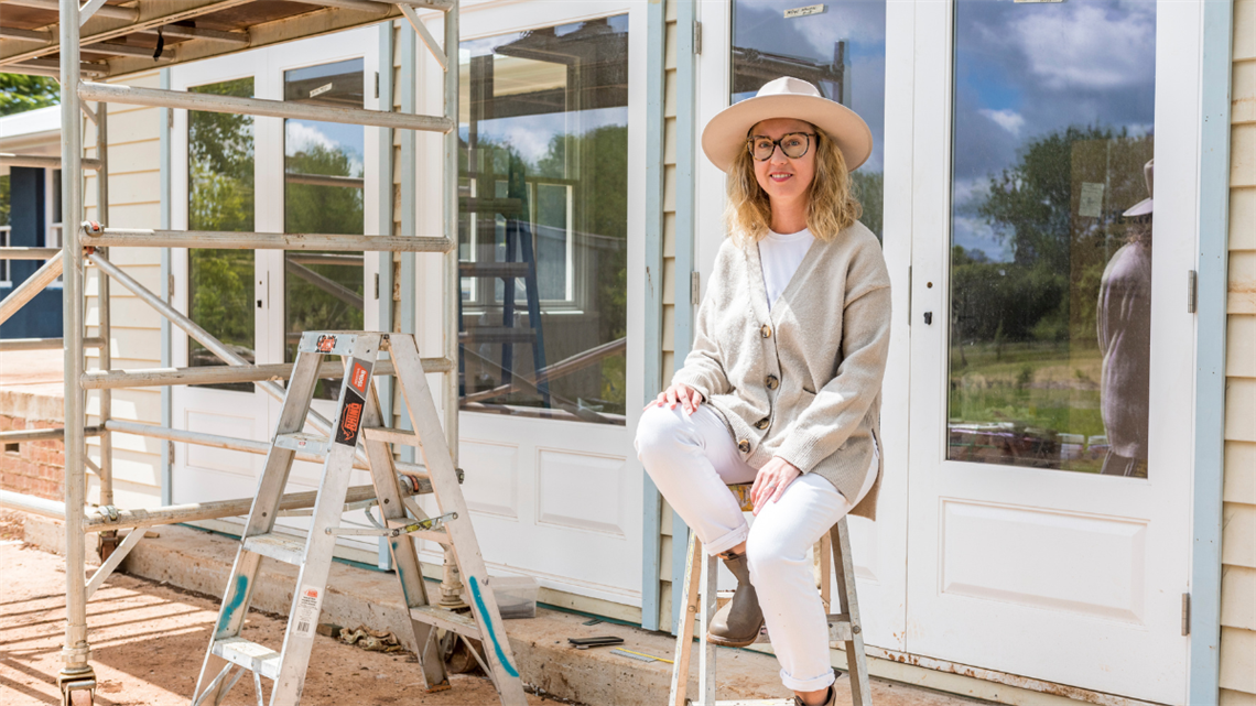 lady sitting on a ladder at her home worksite