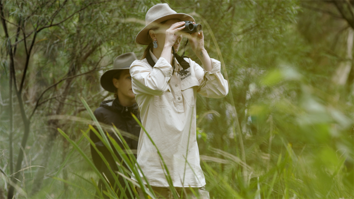 Casey Taylor looking through the bush with bonoculars