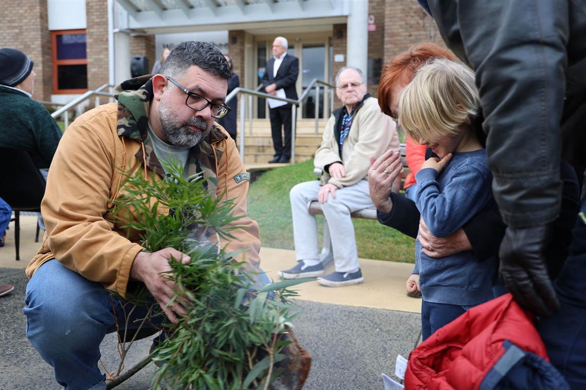 Image of smoking ceremony showing a young child watching on 