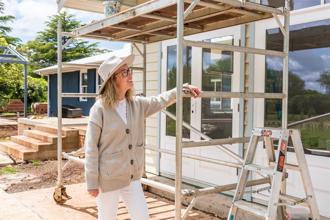 Woman in backyard looking at house extension works