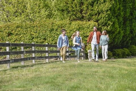 Happy family going for a walk outside with their dog