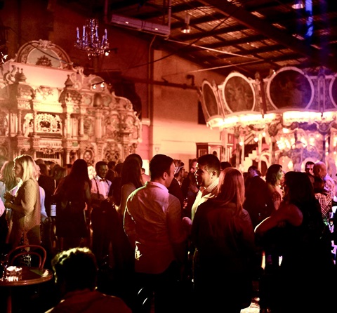 Image of people at an event with carousel in the background