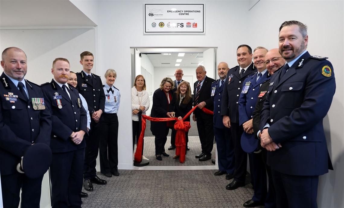 Officials including Emergency service personnel in unform taking part in ribbon cuttiing ceremony