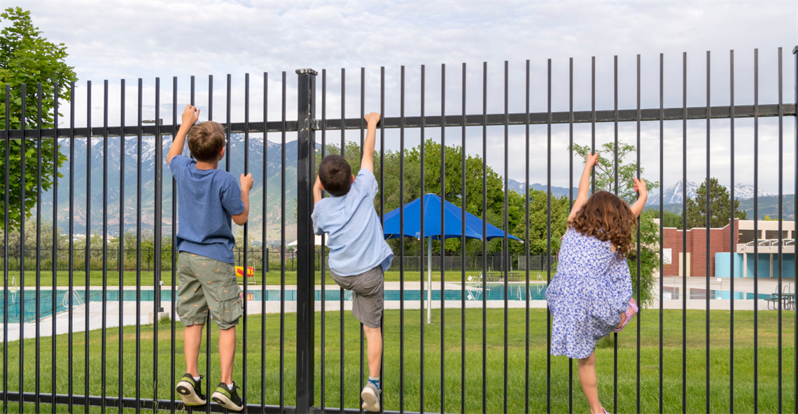 Children looking over a pool fence