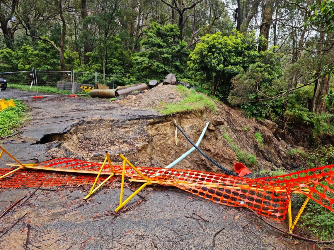 Flood damaged Robinson Street Culvert, Mittagong with severe erosion and exposed pipes barricaded off 