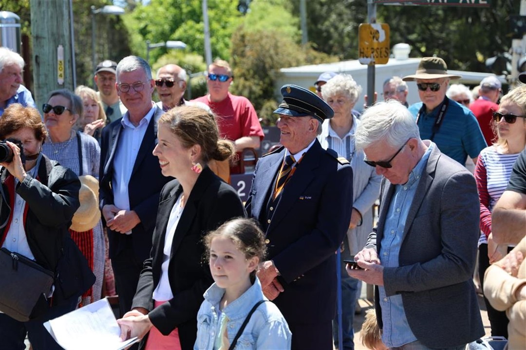 Community members gather smiling, including man in City Rail uniform for opening of Bundanoon Railway Station