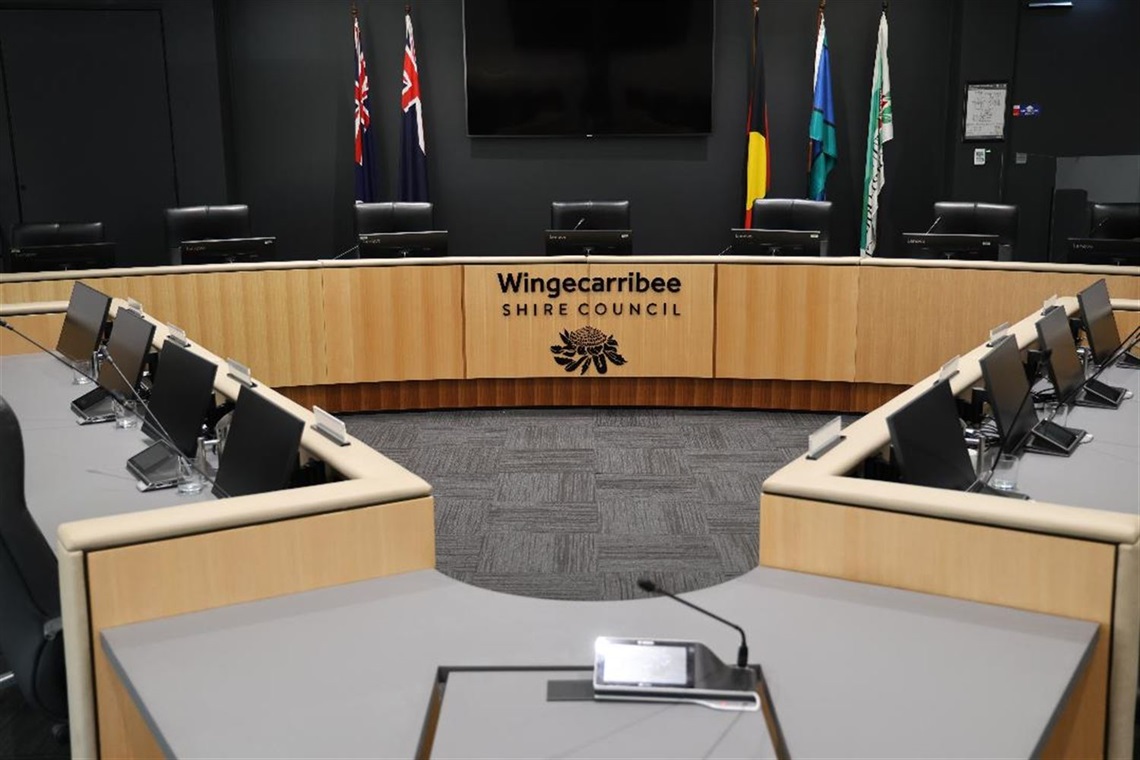 Wingecarribee Shire Council Chambers councillor and executive seats with logo and flags 